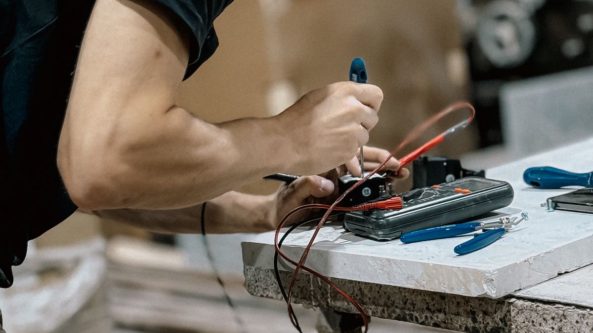 Technicien réalisant un contrôle de maintenance sur une armoire électrique industrielle